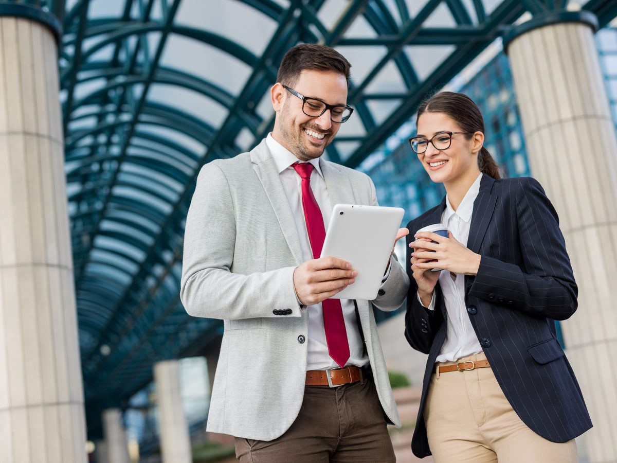 Two Cloud Bridge consultants reviewing figures on a tablet